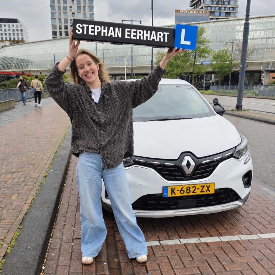 Geslaagde leerling met het bord van Autorijschool Stephan Eerhart