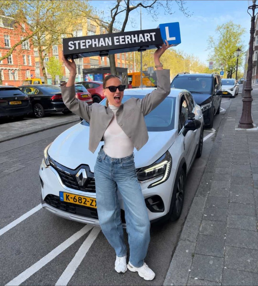 Geslaagde leerling met het bord van Autorijschool Stephan Eerhart
